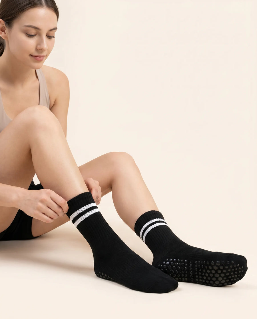 Woman putting on Numan mid-calf pilates socks