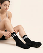 Woman putting on Numan mid-calf pilates socks
